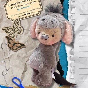 May include: A gray and pink stuffed Eeyore toy from Winnie the Pooh, with a long tail. The toy is 6 inches tall and is part of a pattern for making teddy bears. The pattern is called "Looking like Pooh's Eeyore" and is by Cat Maessen. The pattern is rated 5 stars for difficulty.
