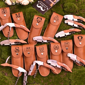 Könnte beinhalten: Eine Sammlung personalisierter Korkenzieher mit Holzgriffen und Edelstahlkomponenten, jeweils in einem braunen Kunstleder-Etui. Die Korkenzieher sind mit Namen und Initialen graviert.