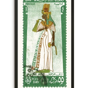 May include: A green postage stamp featuring a woman in a white pharaonic dress with a golden headdress. The stamp is from the United Arab Republic and is dated 1968. The text on the stamp reads "UAR Postage 1968" and "Pharaonic Dress 55 Pos Day 00".