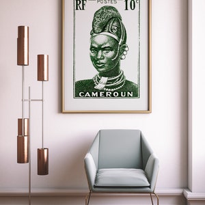 May include: A framed vintage poster with a green illustration of a woman wearing traditional African headwear and jewelry. The poster reads "RF POSTES 10c CAMEROUN".