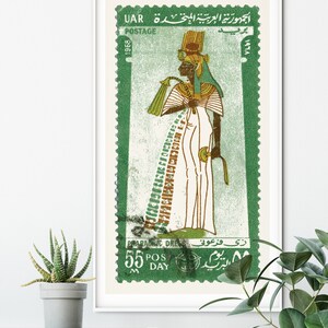 May include: A vintage postage stamp from the United Arab Republic (UAR) featuring a green background and a depiction of an Egyptian pharaoh in a white robe and a gold headdress. The stamp reads "جمهورية العربية المتحدة UAR" and "1968" in Arabic and English. The text "PHARAONIC DRESS" and "5.5 POS DAY" are also visible.