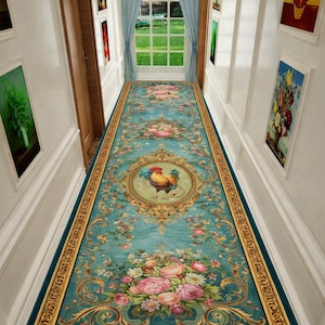 May include: A long, ornate teal runner rug with a detailed floral and rooster design. The rug features a central medallion with a rooster, surrounded by pink and white roses and gold accents. The edges are bordered with a dark teal.