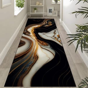 Könnte beinhalten: Ein langer, rechteckiger Teppich mit Marmormuster. Der Teppich weist ein fließendes Muster aus Schwarz, Weiß und Gold auf, das eine luxuriöse und elegante Ästhetik erzeugt. Das Design ähnelt Naturstein mit wirbelnden Adern.