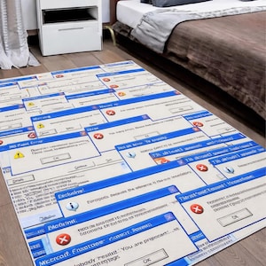 Könnte beinhalten: Ein rechteckiger Teppich mit einem sich wiederholenden Muster aus blauen und weißen Computerfehlermeldungsfenstern. Der Teppich hat einen beigefarbenen Hintergrund und liegt auf einem Holzboden. Das Design des Teppichs enthält Text wie "MS Paint Error" und "Critical Error".