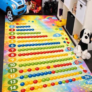 Peut inclure: Un tapis de jeu coloré pour enfants avec un arc-en-ciel et les chiffres 1 à 20. Le tapis présente des rangées de cercles colorés, un arc-en-ciel et des étoiles. Une voiture jouet et un chien en peluche sont visibles.