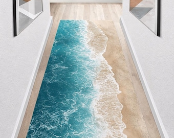 May include: A rectangular rug featuring a beach scene with turquoise water and foamy white waves meeting a sandy shore. The rug is designed to resemble a coastal landscape, creating a serene and natural aesthetic.