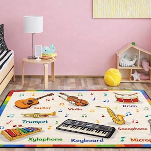 May include: A rectangular rug with a colorful border features musical instruments and their names. Instruments include a guitar, violin, drum, trumpet, xylophone, keyboard, saxophone, and microphone. Musical notes are scattered across the rug.