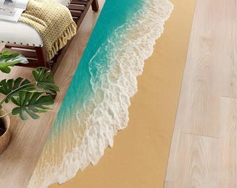 May include: A rectangular rug featuring a beach scene with turquoise water and white foamy waves washing onto a sandy shore. The rug's design creates a realistic ocean view, suitable for a coastal-themed interior.