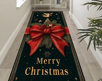 Op de afbeelding: Een rechthoekig kersttapijt met een donkergroene achtergrond en een grote rode strik als centraal designelement. Het tapijt heeft de woorden "Merry Christmas" in goud, samen met sterren en een gouden rand.