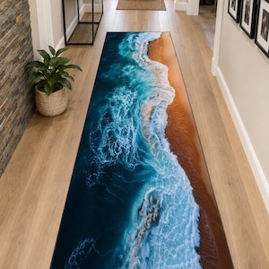 Peut inclure: Un tapis de couloir rectangulaire avec un motif de vagues océaniques. Le tapis présente un océan bleu profond avec des vagues blanches et mousseuses s'écrasant sur une plage de sable. Le tapis est placé dans un couloir avec un plancher en bois clair.