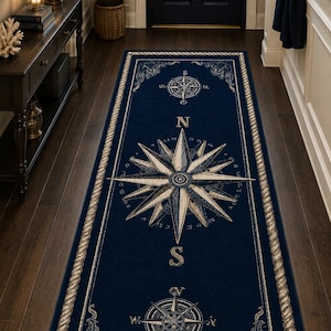 Peut inclure: Un long tapis de couloir rectangulaire bleu marine profond orné d'une grande rose des vents centrale aux accents beiges et blancs. La bordure présente un motif de corde et des motifs de boussole plus petits sont placés aux deux extrémités.