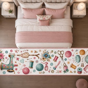 Puede incluir: Una alfombra rectangular con fondo blanco que presenta un patrón repetitivo de artículos de costura, incluyendo una máquina de coser antigua, ovillos de lana de colores, carretes de hilo, tijeras, botones, dedales y arreglos florales.