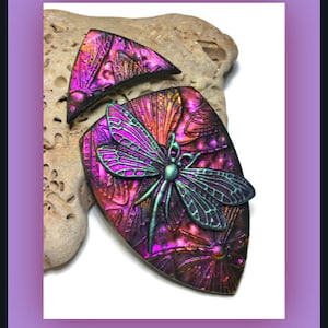 May include: A white ceramic mug with a black handle and the text "But First, Coffee" in a bold, black font. The mug is set against a blurred background, suggesting a cozy setting.