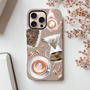 Może przedstawiać: Etui na telefon z motywem kawy. Projekt przedstawia ziarna kawy, filiżankę latte art, ekspres do kawy przelewowej i dłoń trzymającą filiżankę kawy. Etui ma jasnobrązowe tło z matowym wykończeniem.