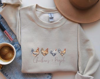 May include: A beige sweatshirt with a graphic of five chickens and the text "Chickens > People".