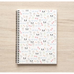 May include: A white spiral bound notebook with a repeating pattern of paw prints, coffee cups, and the text "Vet Med" in blue.