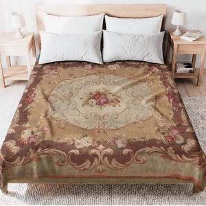 Può includere: Un copriletto a fantasia floreale nei toni del beige e del marrone. Il copriletto presenta un motivo floreale centrale con rose e un bordo decorativo. Il letto è composto da cuscini bianchi e da un telaio in legno.