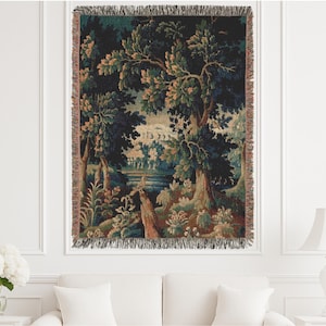 May include: Woven tapestry throw blanket featuring a detailed forest scene with trees, foliage, and a body of water. The color palette includes shades of green, brown, and blue, with a fringed edge.