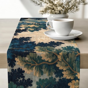 May include: A rectangular table runner featuring a repeating pattern of stylized trees and foliage in shades of deep navy blue, forest green, and muted beige. The fabric has a textured appearance with a detailed botanical print across the surface.