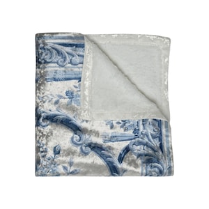 Luxury crushed velvet throw blanket featuring an antique-inspired vintage French Aubusson blue and white floral Marie Antoinette design. Soft, fluffy, comfy and cozy, this heritage design elevates home decor in any bedroom or living room. Style it on a sofa, as a bed cover or bedspread in traditional, grandmillennial, French country, or shabby chic interiors. A refined gift for art lovers.