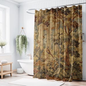 May include: A shower curtain with a detailed tapestry design featuring a forest scene with trees, birds, and foliage in shades of brown, green, and beige. The curtain hangs in a white bathroom with a tub and a hanging plant.