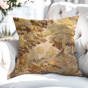 Könnte beinhalten: Quadratisches Zierkissen mit einem Landschaftsdesign in Braun-, Beige- und Goldtönen. Das Kissen zeigt eine detaillierte Illustration von Bäumen, Blättern und einem Pfad, die eine Vintage-Ästhetik erzeugt. Das Kissen liegt auf einer weißen Oberfläche.