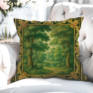 Puede incluir: Cojín decorativo cuadrado con una pintura de paisaje de un bosque. La obra de arte está enmarcada con un borde dorado y verde ornamentado. El cojín está colocado sobre una superficie blanca.