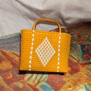 Bolso de mano tejido a mano con estampado amarillo y blanco
