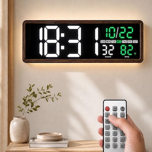 Puede incluir: Un reloj de pared digital rectangular con marco de madera oscura que muestra la hora en grandes números LED blancos, la fecha 10/22 en verde, el día de la semana, un contador de segundos y la temperatura en Fahrenheit con mando a distancia.