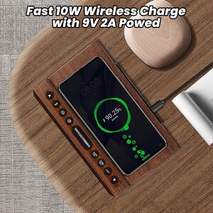 May include: A wooden wireless charging pad with a black smartphone on top. The phone is charging and shows a battery icon with 90.25% charged. The charging pad has a button labeled "SNOOZE/DIMMER" and a button labeled "LIGHT".