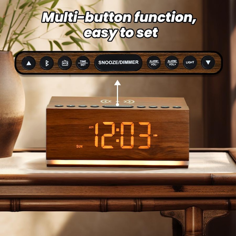 May include: A wooden alarm clock with a digital display showing 12:03 AM. The clock has a built-in wireless charging pad and multiple buttons for setting the time, alarm, and other functions. The clock is sitting on a wooden table.