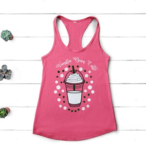 May include: Pink tank top with a white graphic of a vanilla bean latte with a white whipped cream topping. The text "Vanilla Bean Latte" is written in white on the tank top.