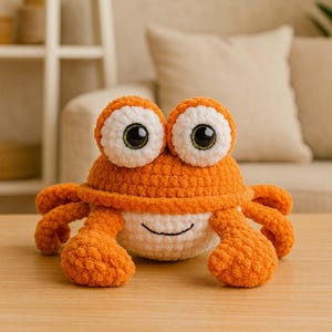Pode incluir: Um brinquedo de pelúcia de caranguejo de crochê laranja e branco feito à mão, com olhos grandes e redondos e um rosto sorridente. O caranguejo tem oito pernas laranja e está sentado em uma superfície de madeira. Um brinquedo de pelúcia caprichoso e fofinho.