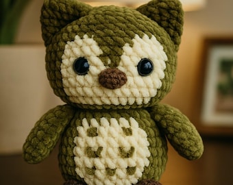 May include: A handmade crochet owl plushie in olive green and cream. The owl has large black eyes, a brown beak, and brown feet. The plushie is a soft, cuddly toy, perfect for a nursery or as a decorative item.