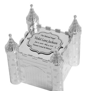 May include: Silver castle-shaped keepsake box with a personalized inscription that reads "Our Beloved Angel Violet Lane Jackson Jan 21, 2016 - May 9, 2016 Forever Loved & Missed".