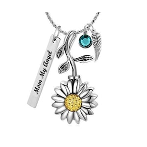 May include: Silver necklace with a sunflower charm, a small blue crystal, a wing charm, and a silver tag that says "Mom My Angel".
