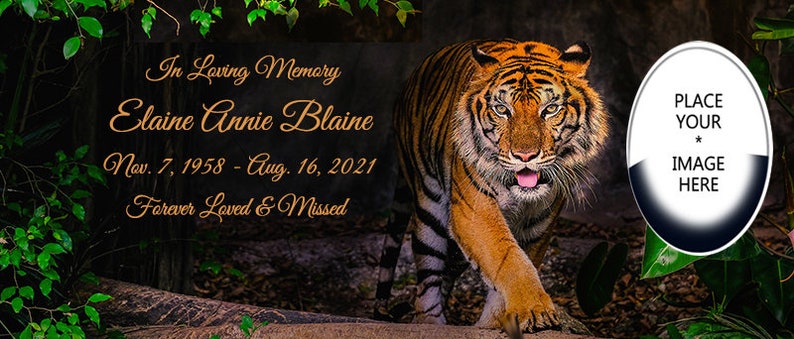 May include: A memorial image featuring a tiger walking through a dark forest with green foliage. The text reads "In Loving Memory Elaine Annie Blaine Nov. 7, 1958 - Aug. 16, 2021 Forever Loved & Missed". A white oval with a black border is in the upper right corner with the text "PLACE YOUR * IMAGE HERE".