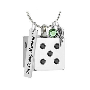 May include: Silver necklace with a dice charm, a small angel wing charm, and a green gemstone. The dice charm has black gemstones on each side and a tag that reads "In Loving Memory".
