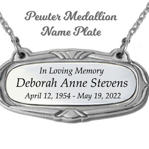 May include: A silver pewter medallion nameplate with the inscription "In Loving Memory Deborah Anne Stevens April 12, 1954 - May 19, 2022".