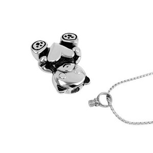 May include: Silver charm necklace featuring a small bear holding a heart. The charm is attached to a silver chain.