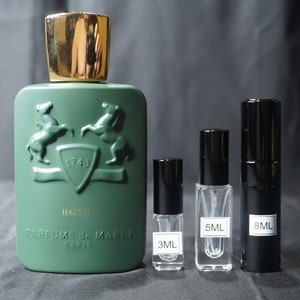 May include: A green bottle of Halfeti perfume by Parfums de Marly Paris. The bottle has a gold cap and a gold emblem with two horses and the year 1743. There are three smaller bottles of perfume in the image, one is 3 ml, one is 5 ml, and one is 8 ml.