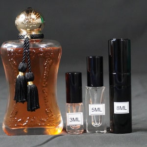 May include: Four perfume bottles, two black and two clear, with gold caps. The bottles are labeled with the volume in milliliters: 3mL, 5mL, and 8mL.