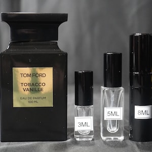 May include: Four bottles of Tom Ford Tobacco Vanille Eau de Parfum. The largest bottle is black with gold lettering and is 100 ml. The other three bottles are smaller and are 3 ml, 5 ml, and 8 ml.