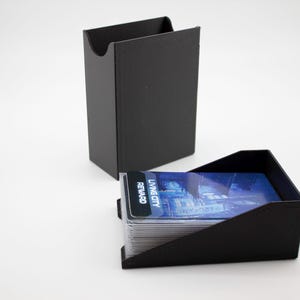 May include: Two black card holders, one upright and one angled, with a stack of cards visible in the angled holder. The cards have a blue and white design with the text "LIVING CITY REWARD".