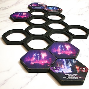 Könnte beinhalten: Ein Brettspiel-Setup mit schwarzen sechseckigen Rahmen und Spielsteinen. Die Spielsteine zeigen eine futuristische Stadtlandschaft in Lila und Rosa. Ein Spielstein trägt die Aufschrift "Spartans' Hideout".