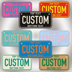 Puede incluir: Una colecci&oacute;n de ocho placas de matr&iacute;cula rectangulares en varios colores, incluyendo rosa, rojo, negro, turquesa, azul claro, naranja, blanco y beige. Cada placa presenta el texto TOP TEXT, CUSTOM y BOTTOM TEXT con dos orificios.
