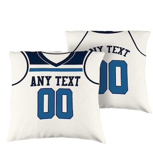 Puede incluir: Dos fundas de almohada blancas con un diseño de camiseta de baloncesto azul y blanca. La funda de almohada delantera tiene el texto "ANY TEXT" y el número "00" en azul. La funda de almohada trasera tiene el texto "ANY TEXT" y el número "00" en azul.