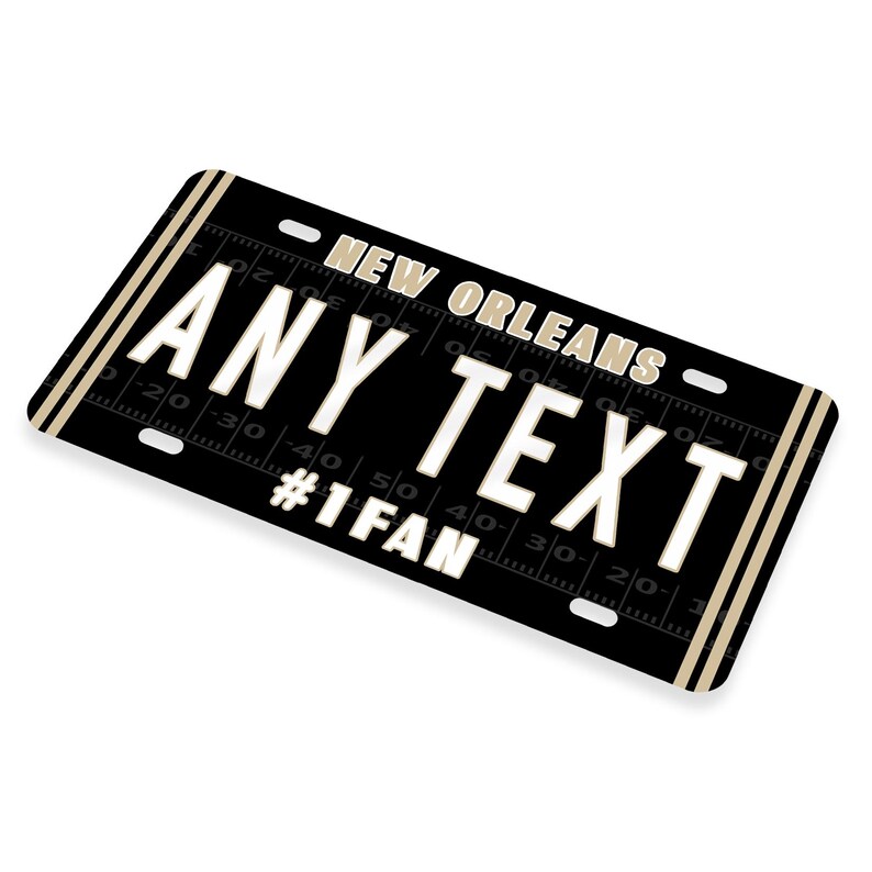 Puede incluir: Placa de matr&iacute;cula negra y dorada de Nueva Orleans con el texto "ANY TEXT #1FAN".