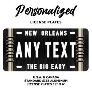 Puede incluir: Una placa de matr&iacute;cula personalizada en blanco y negro con el texto "NEW ORLEANS" y "THE BIG EASY" sobre un fondo negro. La placa tiene un borde blanco y remaches dorados. El texto "ANY TEXT" est&aacute; en el centro de la placa. La placa mide 12 pulgadas por 6 pulgadas.
