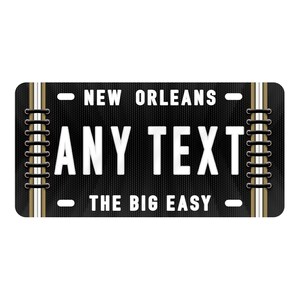 Puede incluir: Se&ntilde;al de estilo placa de matr&iacute;cula en blanco y negro con el texto "NEW ORLEANS" y "THE BIG EASY" en la parte superior e inferior. El centro de la se&ntilde;al dice "ANY TEXT" en letras blancas.